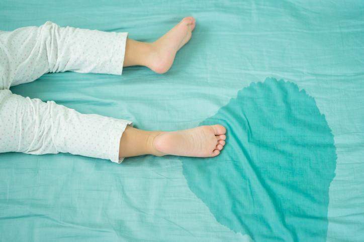 Why do children urinate in bed according to psychology?
